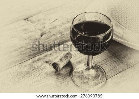 red wine glass on wooden table. vintage filtered image. black and white style photo