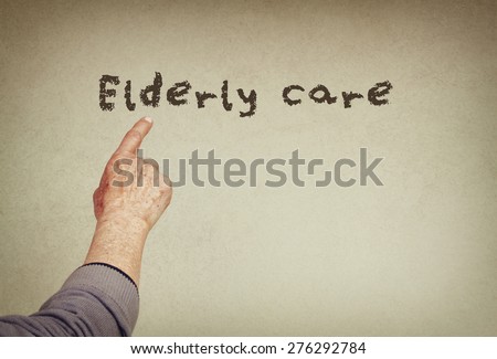 senior man hand pointing at text with the phrase elderly care. room for text