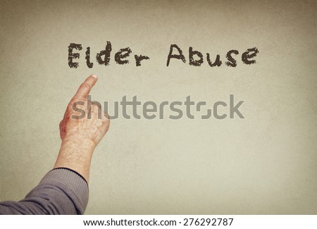 senior man hand pointing at text with the phrase elder abuse. room for text