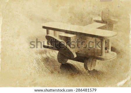 wooden airplane toy over textured wooden background. retro style image.  black and white old style photo