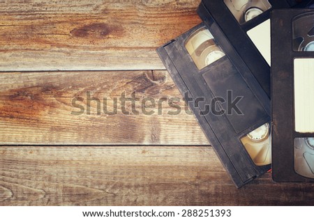 stack of VHS video tape cassette over wooden background. top view photo. retro style image