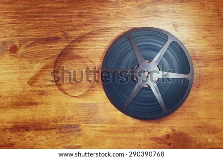 top view image of old 8 mm movie reel over wooden background