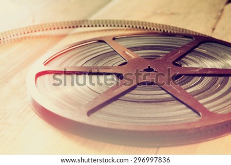 close up  image of old 8 mm movie reel over wooden background. retro style image