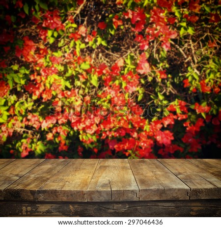 wood board table in front of autumn flowers with double exposure of flower bloom