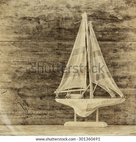 old vintage wooden white sailing boat on wooden table. nautical lifestyle concept. old style black and white photo