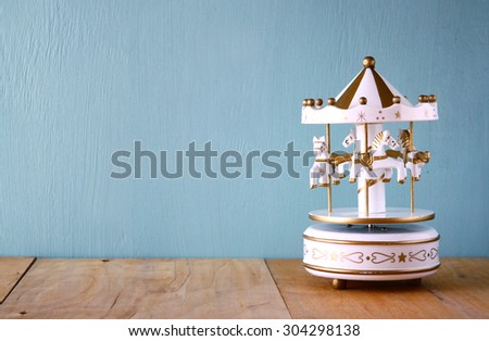old vintage white carousel horses on wooden table