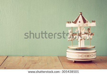 old vintage white carousel horses on wooden table. retro filtered image