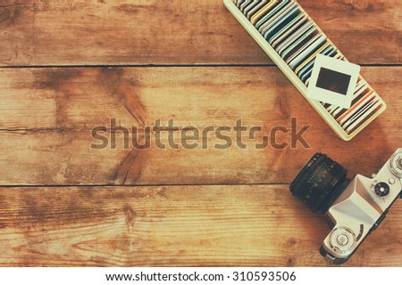 close up image of old slides frames and old camera over wooden table