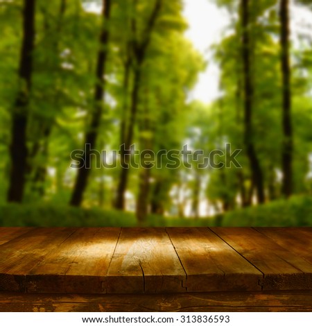vintage wooden board table in front of dreamy autumn abstract forest landscape