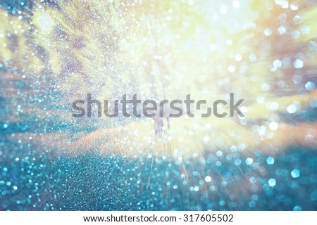 abstract photo of light burst among trees and glitter bokeh lights. image is blurred and filtered .