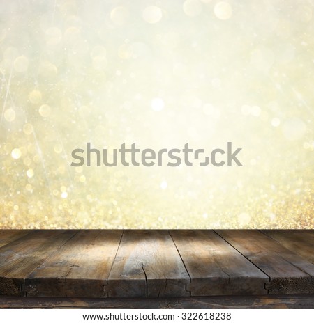 rustic wood table in front of glitter gold and white bright bokeh lights