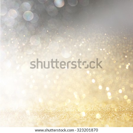 glitter vintage lights background. gold, silver, and black. de-focused.