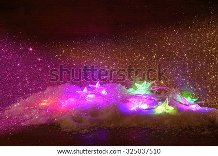 Christmas colorful  garland lights on wooden rustic background. filtered image with glitter overlay