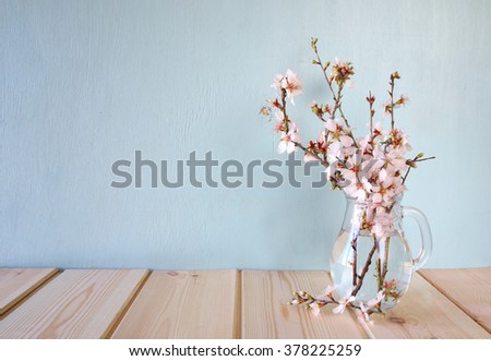 spring bouquet of flowers on the wooden table with mint background. vintage filtered image