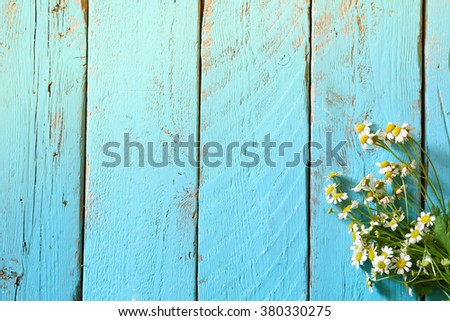 top view image of daisy flowers on blue wooden table. vintage filtered