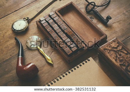 detective concept. Private Detective tools: magnifier glass, old keys, smoking pipe, notebook. top view. vintage filtered image