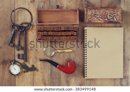 detective concept. Private Detective tools: magnifier glass, old keys, smoking pipe, notebook. top view. vintage filtered image