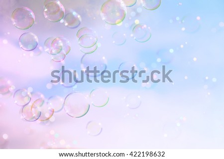Soap bubbles floating in the air against soft clouds and sky. filtered image. selective focus