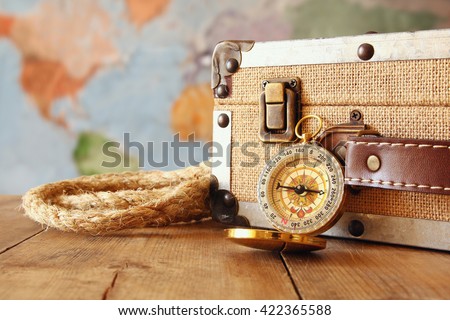 traveler vintage luggage and compass on wooden table. explorer and adventure concept