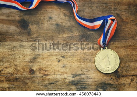 top view image of medal gold over wooden textured table