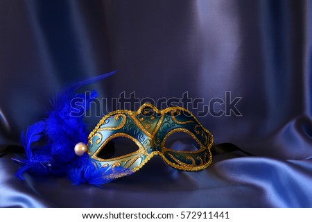 Image of elegant venetian mask on blue silk background