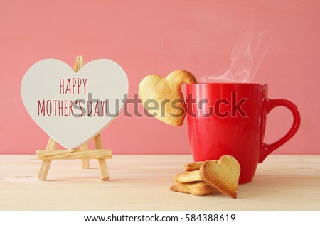 mother\'s day concept image. Board next to cup of coffee and heart cookies