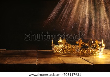 low key image of beautiful queen/king crown over wooden table. vintage filtered. fantasy medieval period