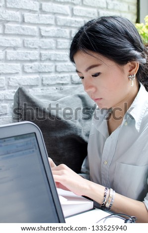 Asian woman thinking about work with laptop computer
