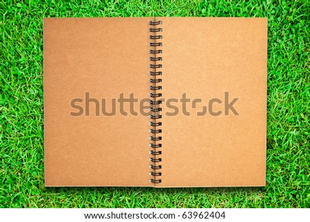 brown recycle paper blank notebook open two page isolated on green grass field  for multipurpose use