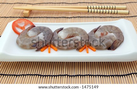 Japanese food,  raw gourmet sushi, tiger king prawns served with a carrot and tomato garnish with copy space,