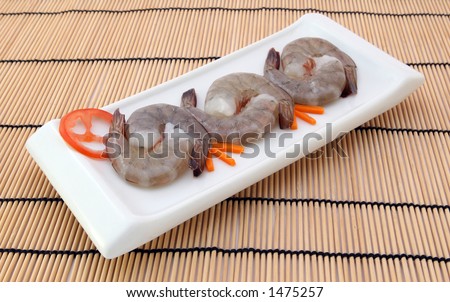 Japanese food,  raw gourmet sushi, tiger king prawns served with a carrot and tomato garnish with copy space,