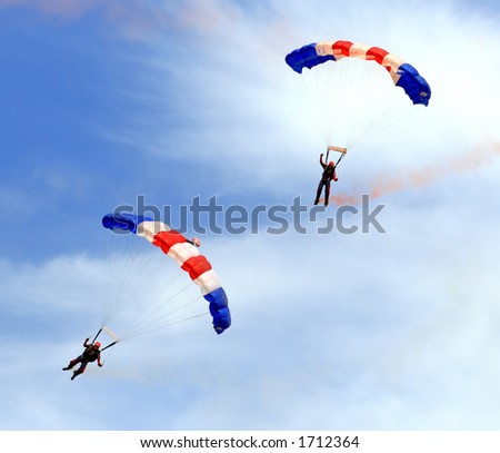 Paratroopers descending in a military skydiving parachute demonstration