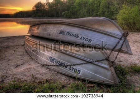 A pair of rental boats by a beautiful lake at sunrise.
