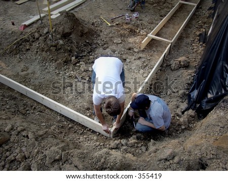 Two men framing house foundations