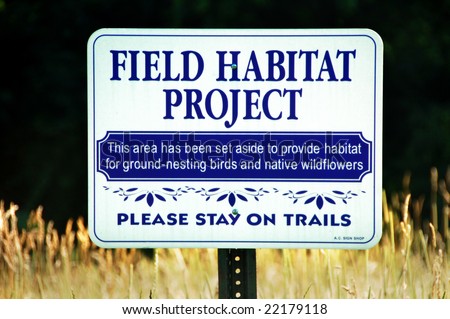 a field habitat project sign to protect ground-nesting birds and native wildflowers
