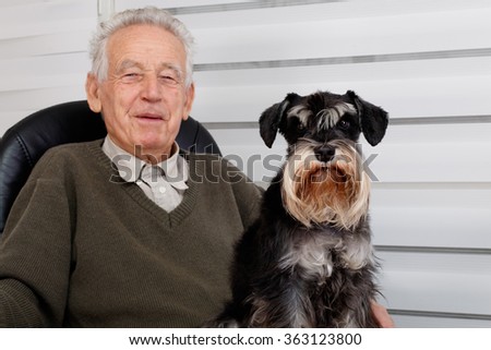Smiling old man and  black Miniature Schnauzer dog