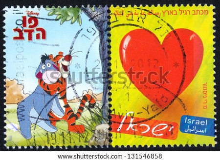 ISRAEL - CIRCA 2009: An used Israeli Postage stamp showing embracing the tiger and the cow and image of the heart on a yellow background; series, circa 2009