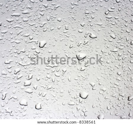 Rain droplets on a grey metallic surface