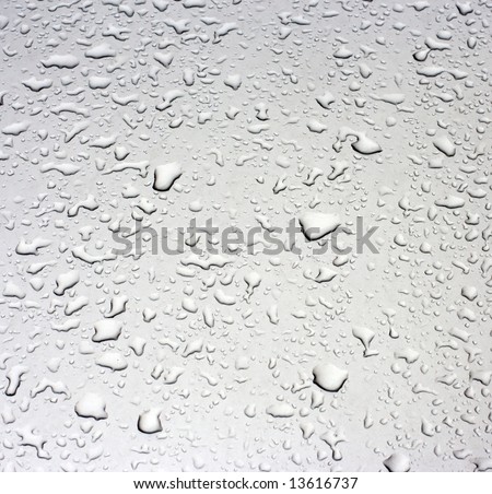 Rain droplets on a grey metallic surface