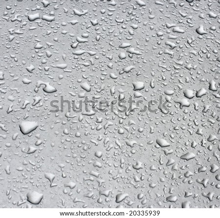 Rain droplets on a grey metallic surface useful for backgrounds