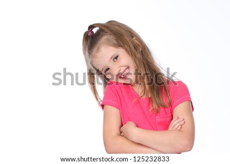 Cute and pretty little girl having a photo shoot wearing jeans and pink t-shirts on a white seamless high key background
