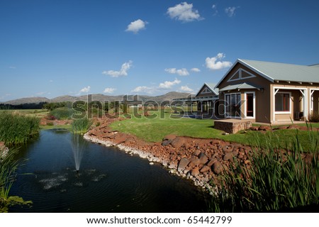 Home in lush countryside by stream with fountain