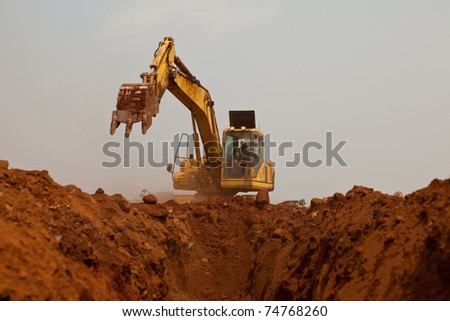Construction digger excavating pipeline trench