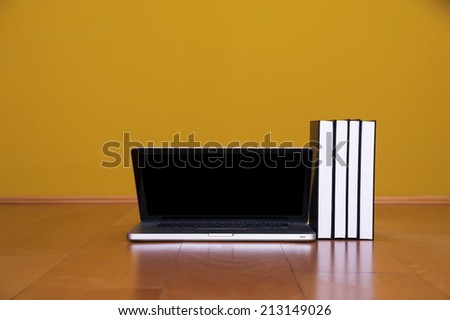 Back to school concept, laptop books coffee mug on wooden floor