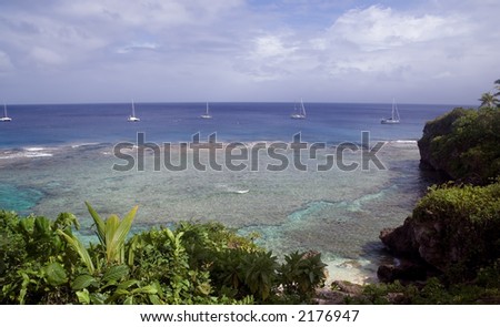 Tropical reef.  Yachts moored just off the reef - Niue island