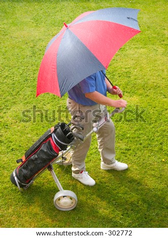 Sun and Rain a golfer caught in a spring shower.waiting for rain to pass.