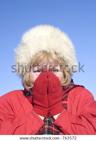 Woman holding her warm hands over her cold nose