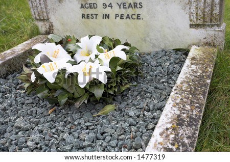 Grave of a 94 year old person, rest in peace, with white flowers
