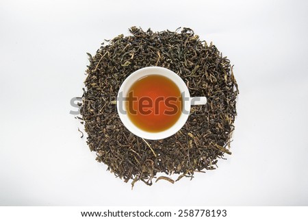Dried tea leaf and the white cup of tea