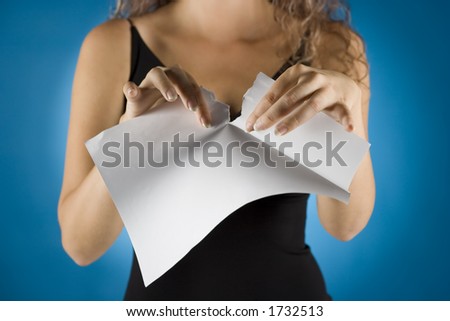 woman tears white piece of paper